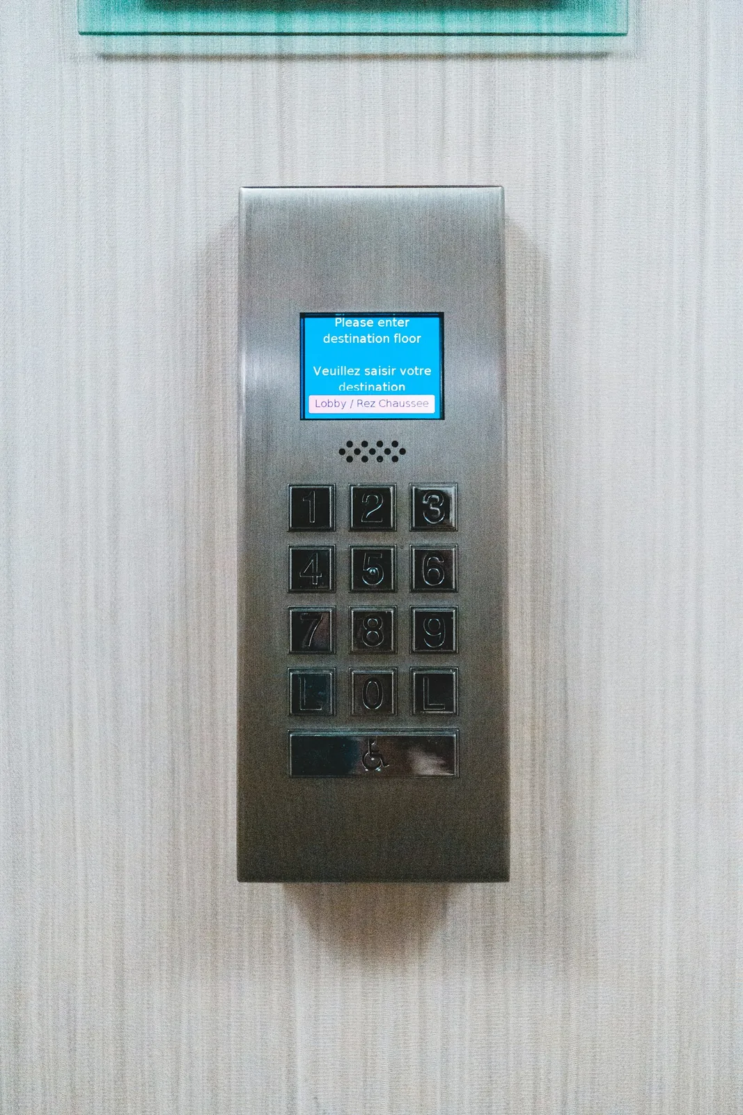 Access control panel with display and keypad at a building entrance